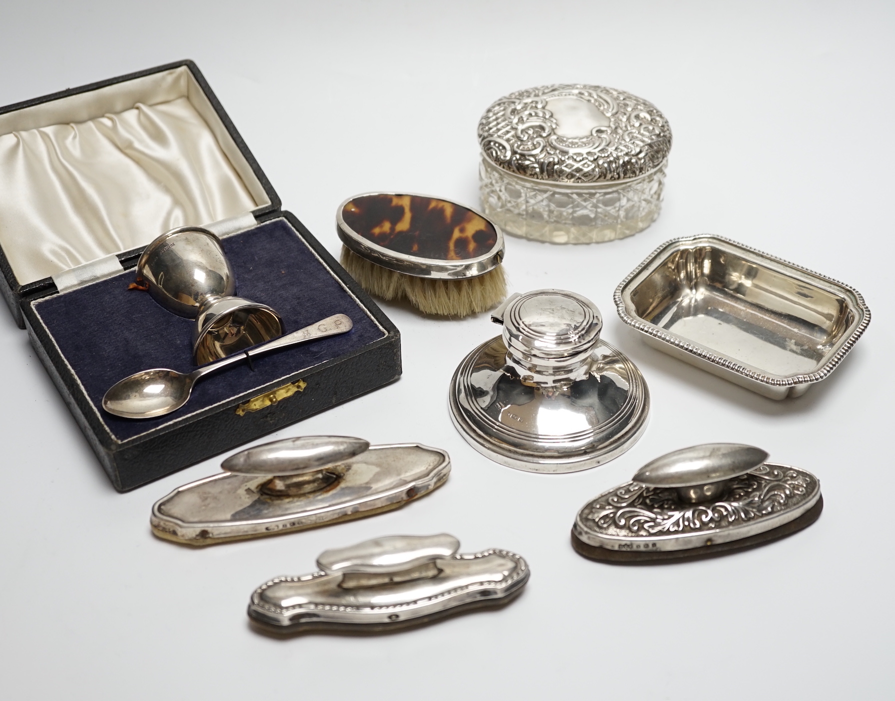 A cased silver christening egg cup and spoon and other items including nail buffers, inkwell, brushes etc.